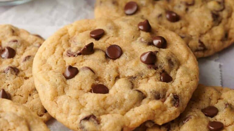 Close-up of several chocolate chip cookies on a surface.