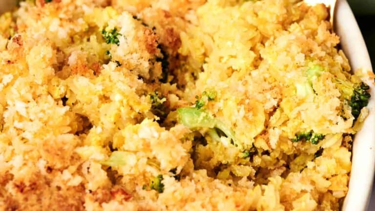 A close-up of broccoli casserole topped with crispy breadcrumbs, showing golden brown baked rice mixed with visible pieces of broccoli.