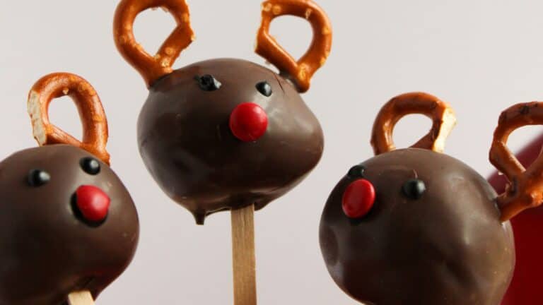 Chocolate cake pops decorated as reindeer with pretzel antlers and candy noses.