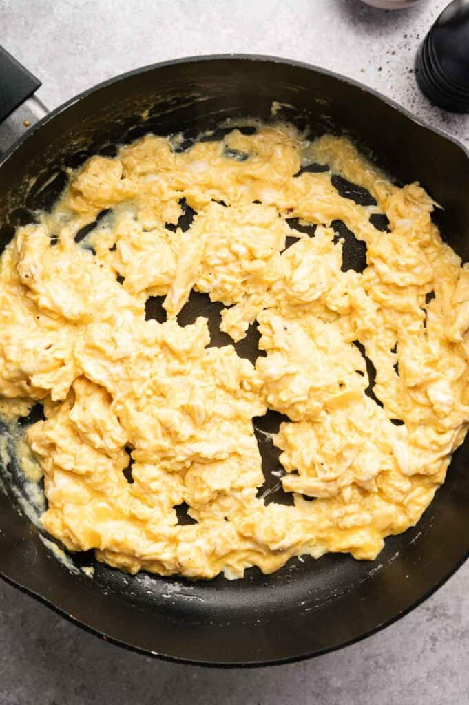 Soft scrambled eggs cooking in a skillet