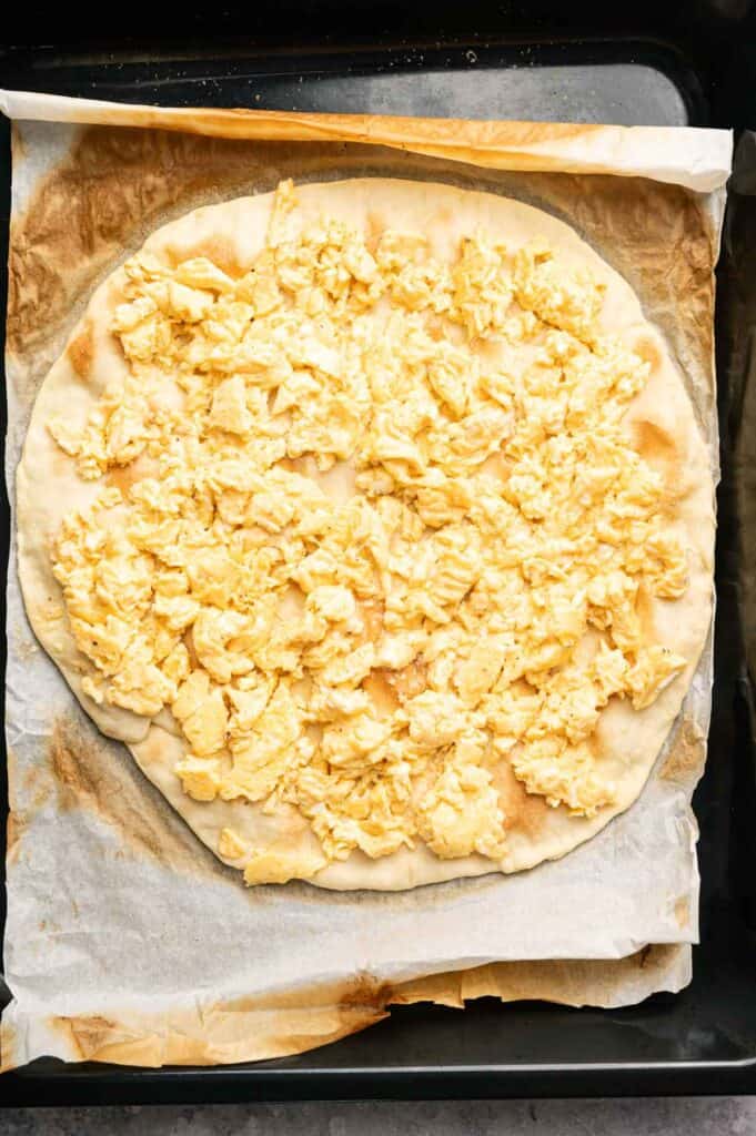 Scrambled eggs spread over a pre-baked pizza crust