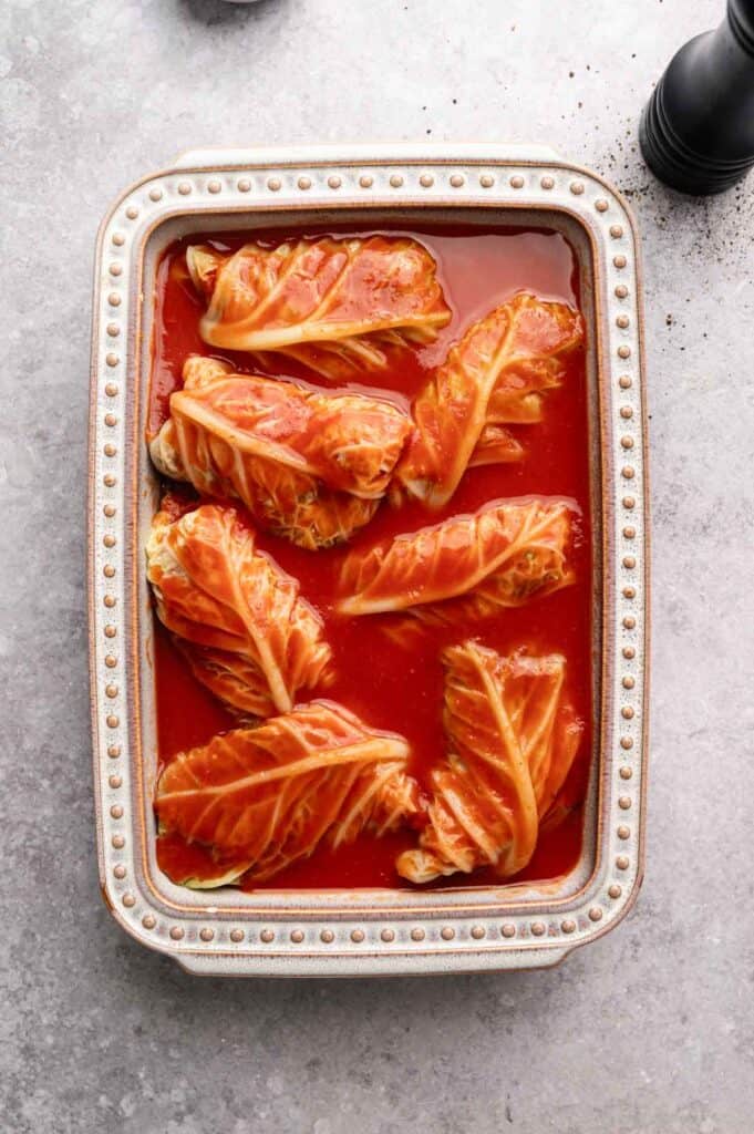 Cabbage rolls covered in tomato sauce before baking