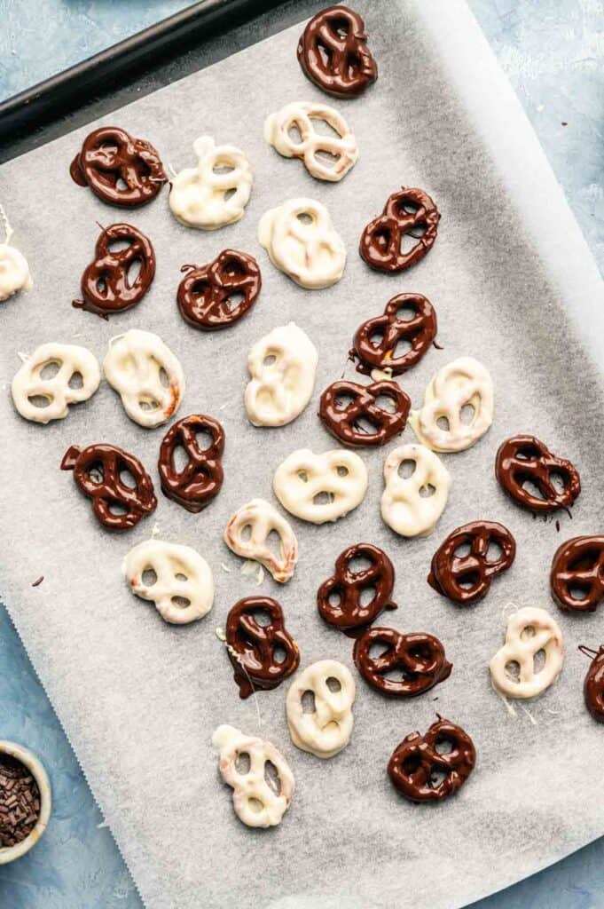 Chocolate-covered pretzels arranged on a lined baking sheet
