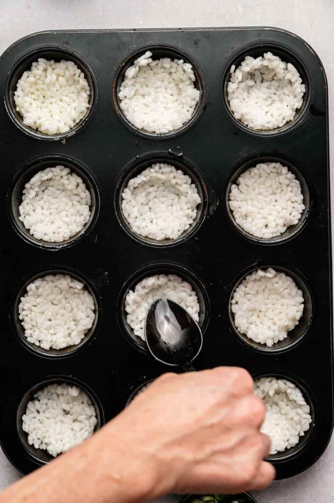 Sushi rice shaped into muffin tin cups before baking