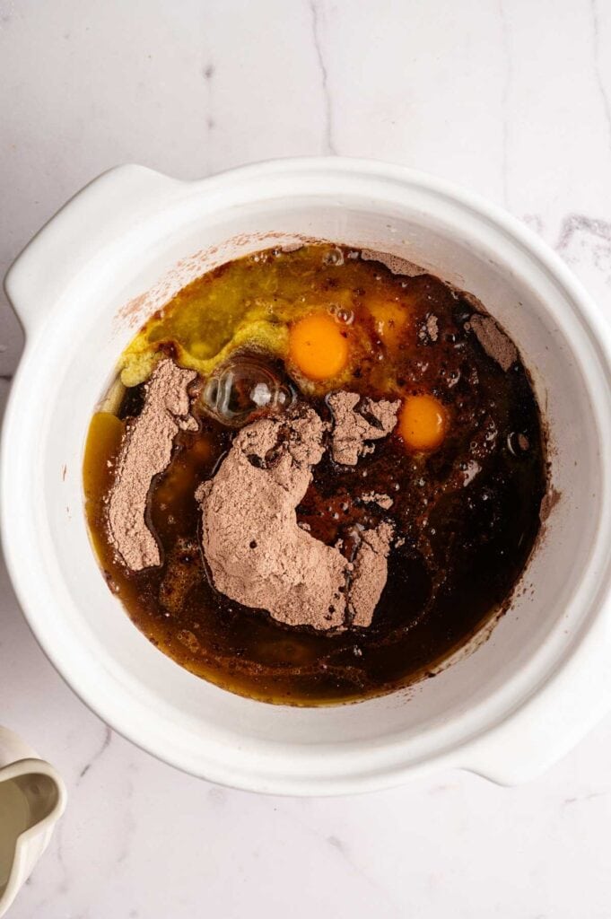 Brownie mix, eggs, oil, and cocoa powder combined in a mixing bowl before stirring