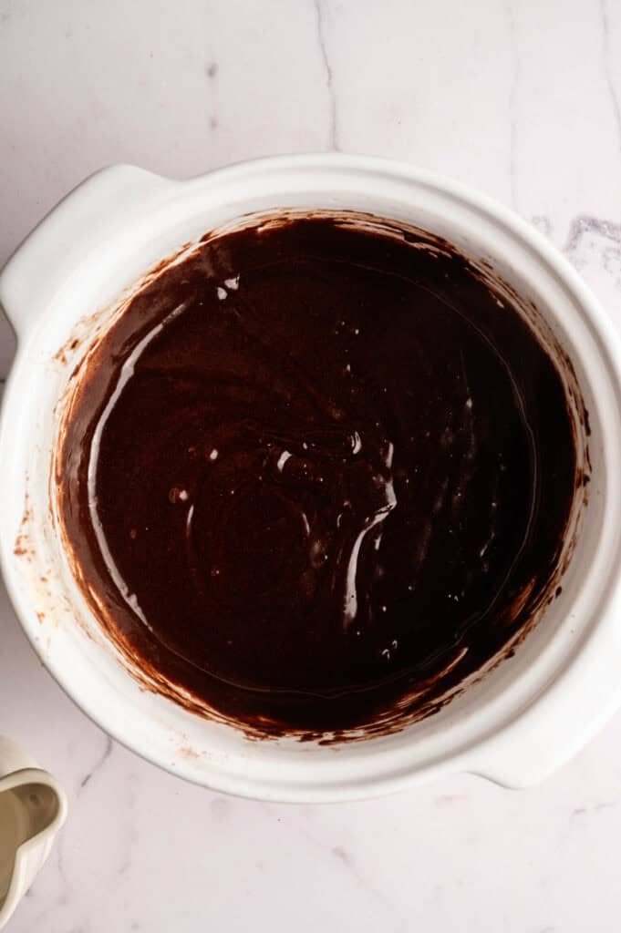 Smooth chocolate brownie batter mixed in a white bowl