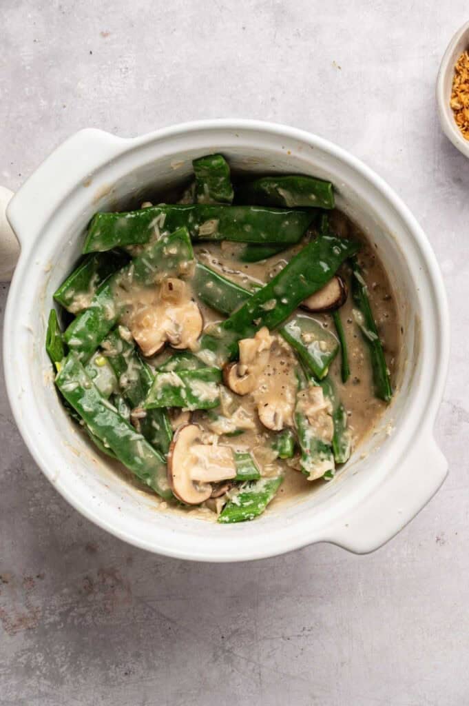 Green beans and mushrooms mixed with creamy sauce in a baking dish