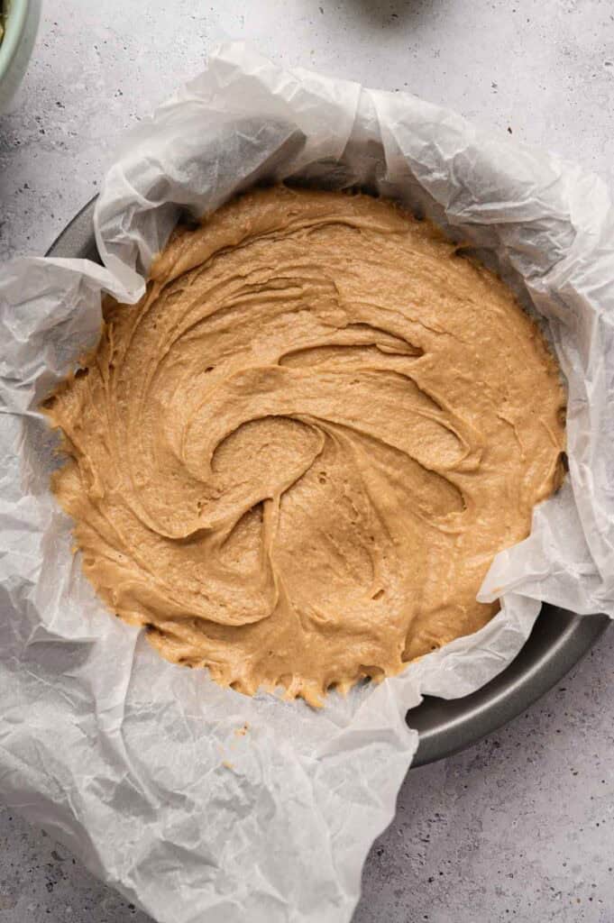 Overhead view of raw Irish apple cake batter smoothed into a round pan