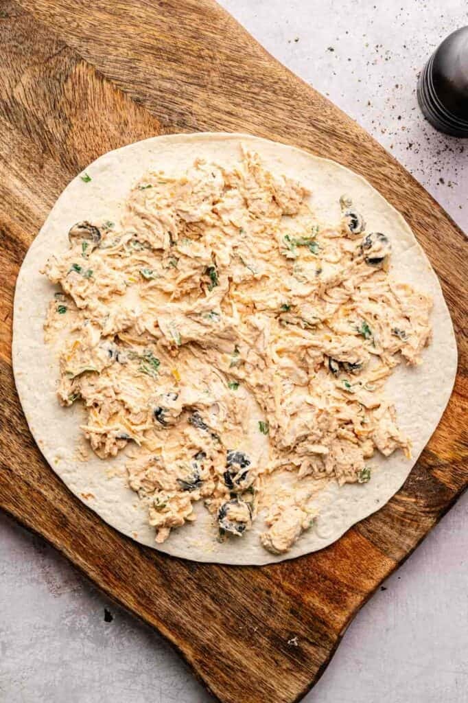 Mexican pinwheel filling spread on a flour tortilla