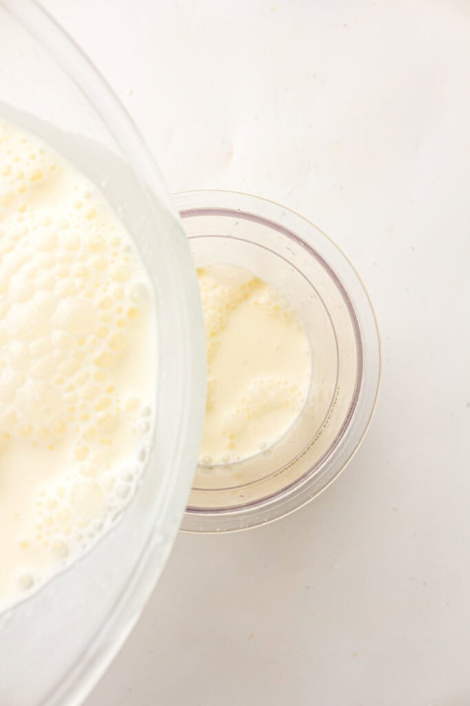 Pouring ice cream base into a Ninja Creami pint container