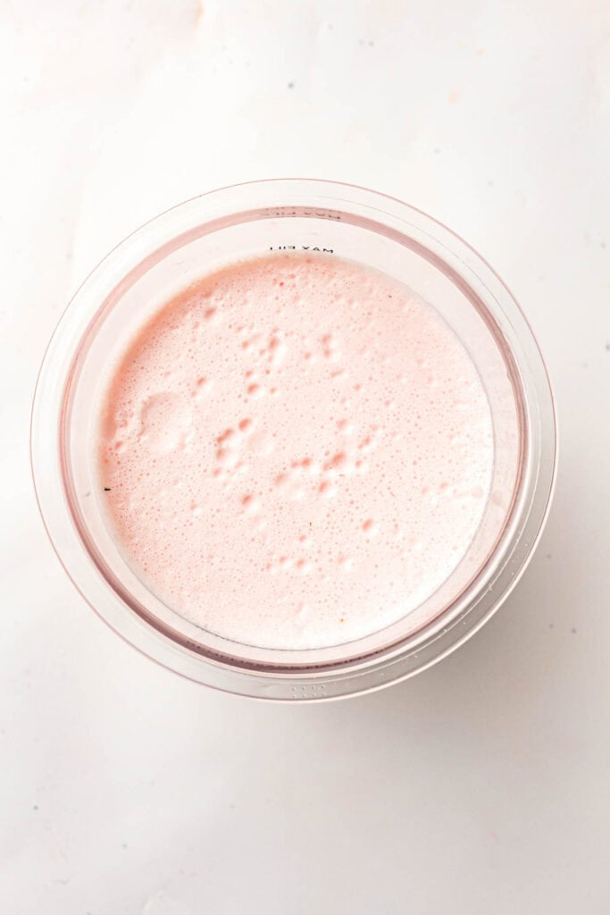 Smooth pink ice cream base poured into a Ninja Creami pint