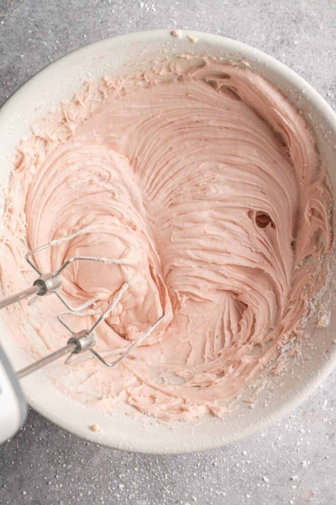 Pink strawberry frosting whipped smooth with electric beaters