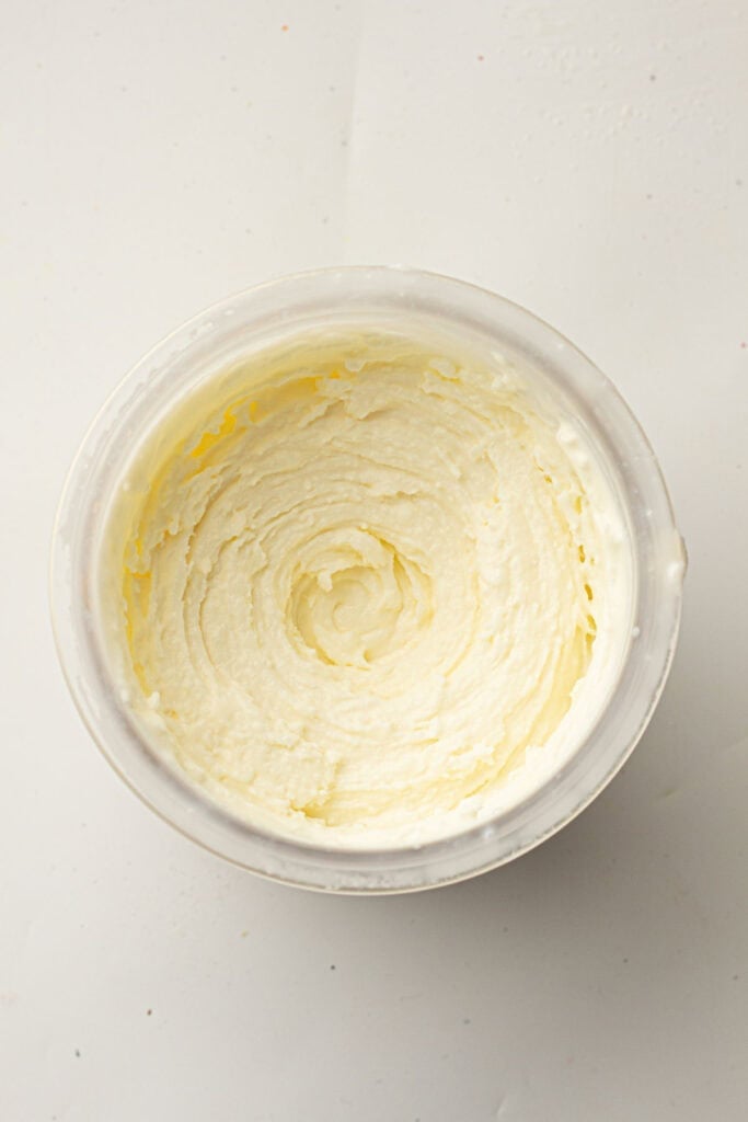 A bowl of whipped butter or frosting viewed from above, with a smooth, creamy texture and spiral pattern&mdash;reminiscent of Vanilla Ninja Creami Ice Cream in its silky appearance.
