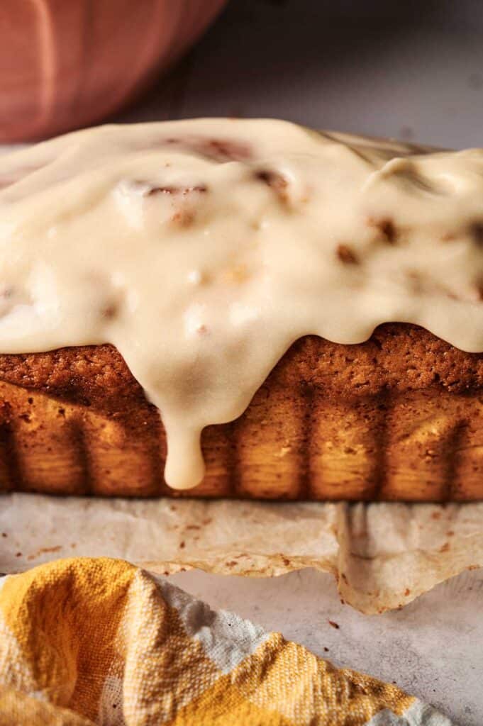 Lemon pound cake loaf covered in glossy lemon glaze on parchment paper