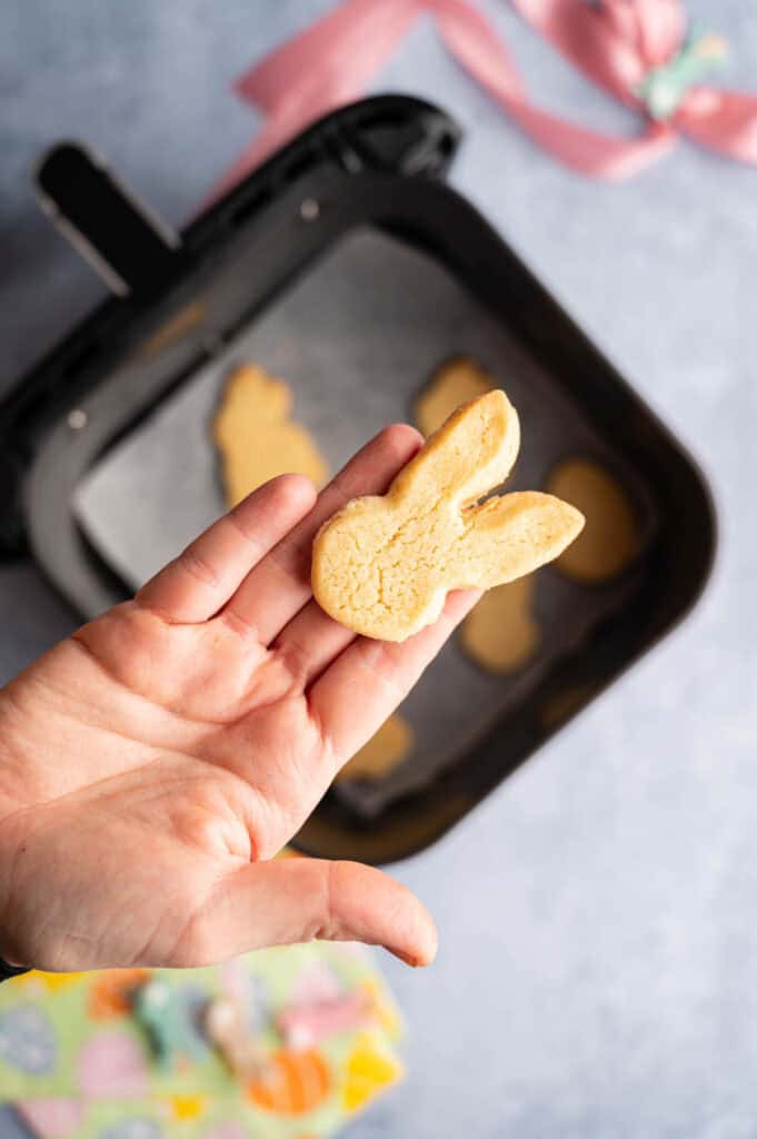 Golden bunny sugar cookie fresh from the air fryer basket, more bunnies visible below