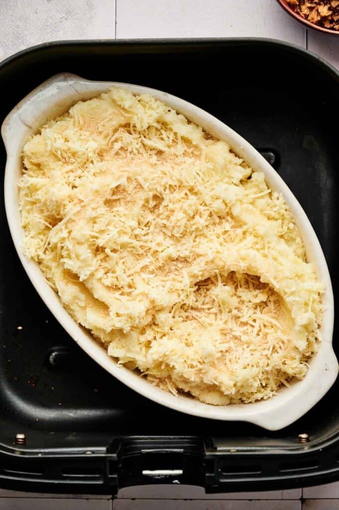 Mashed potato casserole topped with cheese in the air fryer basket