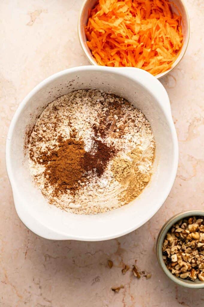 Dry ingredients for carrot cake cookies with cinnamon and ginger piled on top before whisking