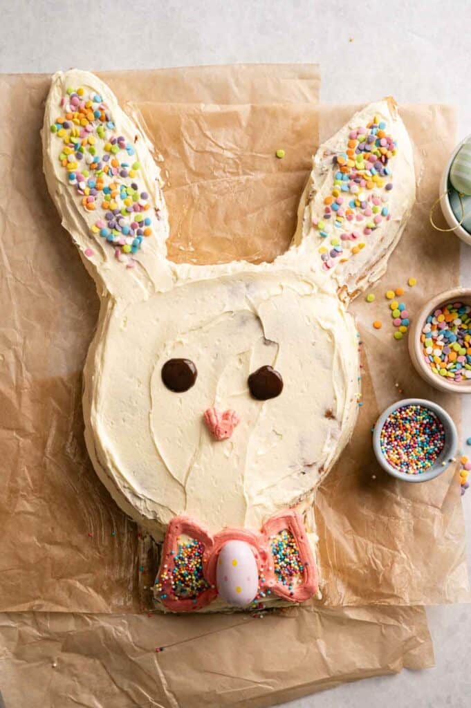 Finished Easter bunny cake with chocolate eyes, pink nose, and a decorated bow tie