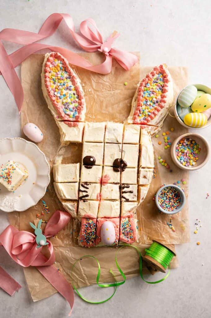 Easter bunny cake sliced into squares with chocolate face and sprinkle-covered ears