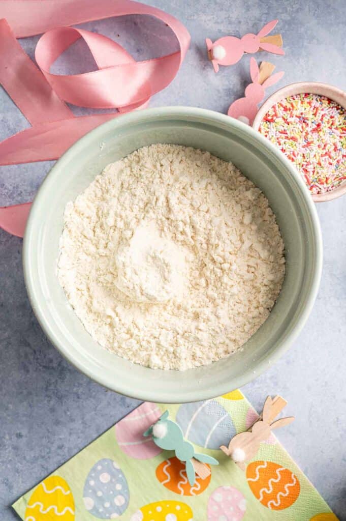 Flour, baking powder, and salt whisked together in a light green mixing bowl