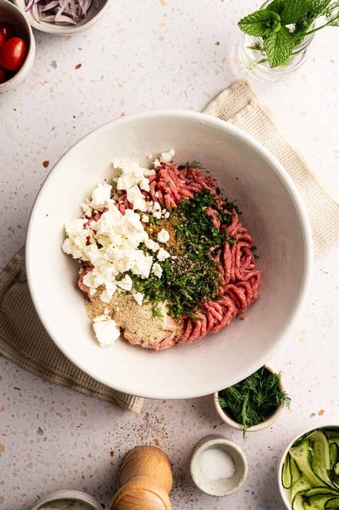 Overhead view of lamb meatball ingredients arranged in a mixing bowl