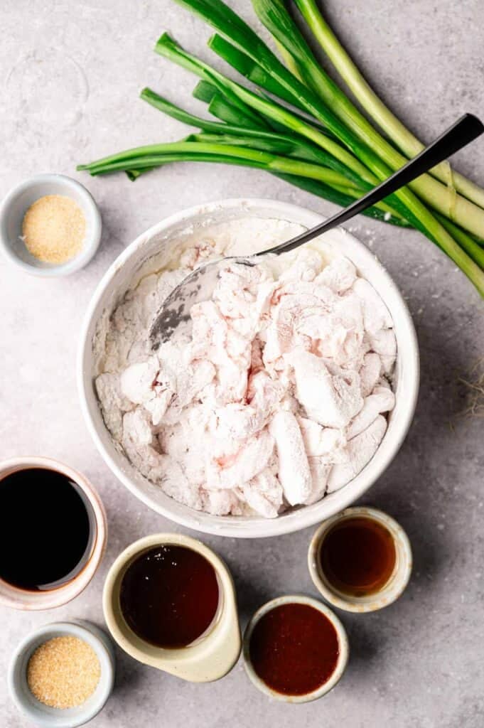 Chicken pieces coated in cornstarch surrounded by soy sauce and honey