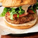 Juicy air fryer turkey burger with fresh lettuce, tomato, and creamy sauce on a toasted bun.