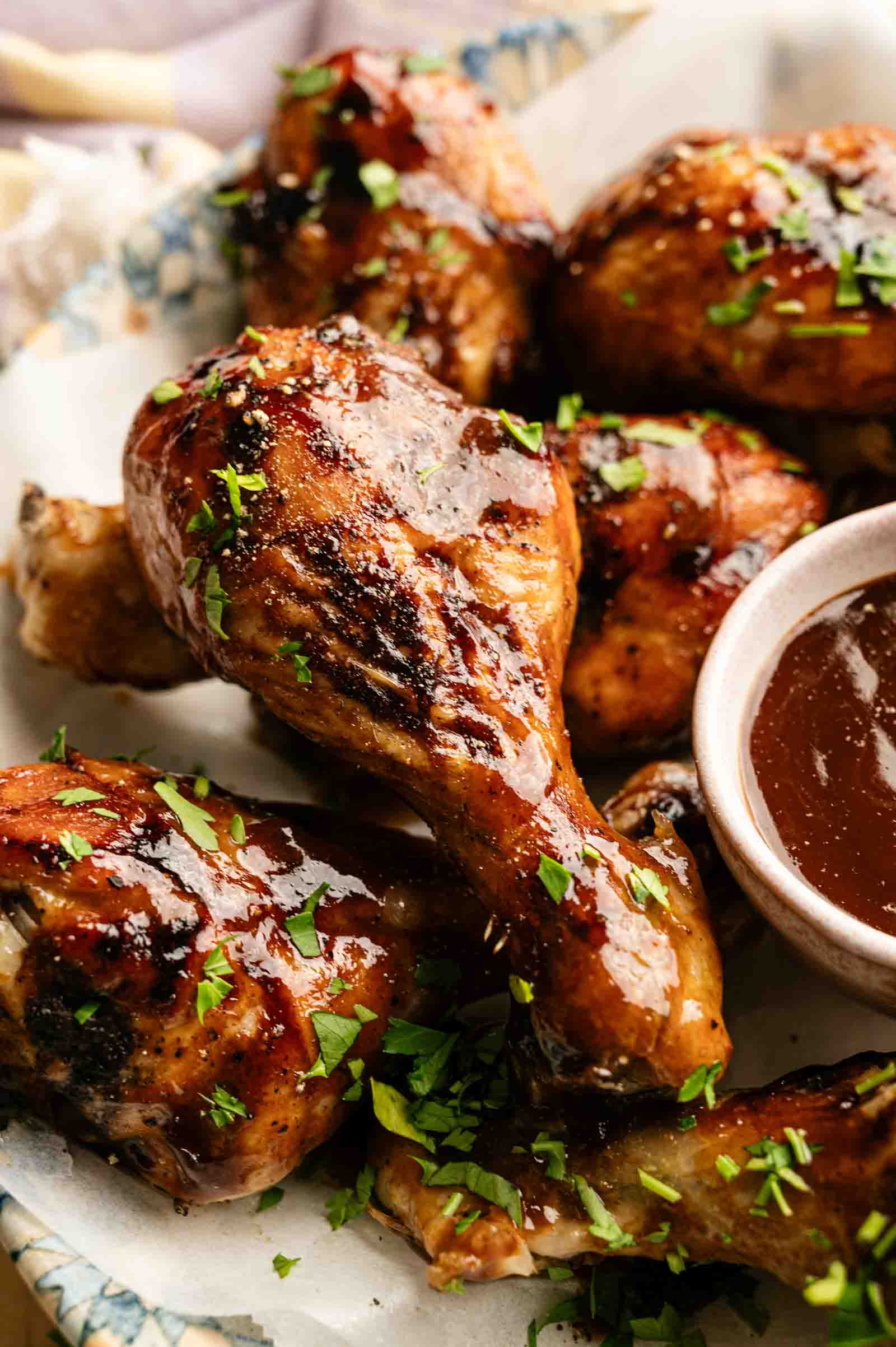 Delicious BBQ chicken drumsticks glazed with savory sauce, garnished with fresh herbs, perfect for backyard cookout.