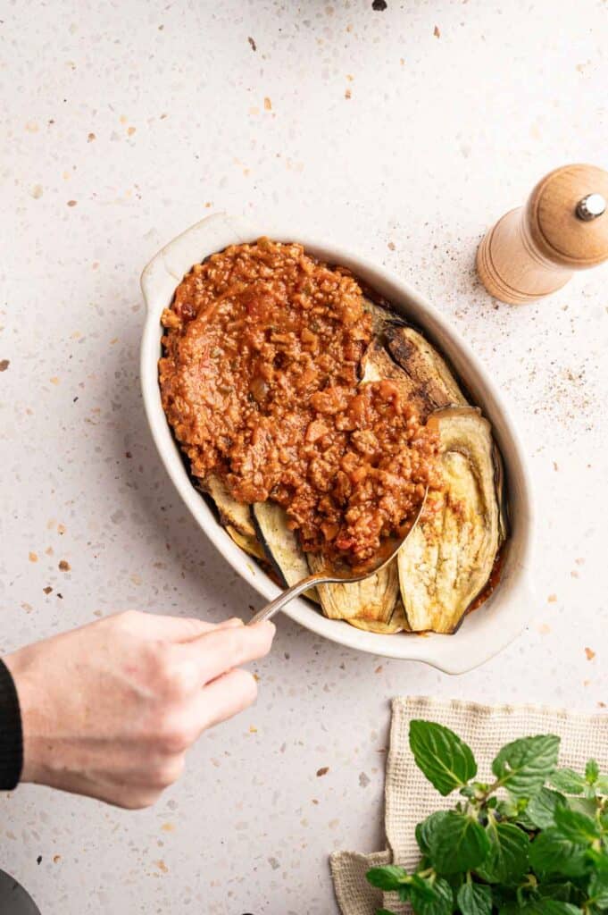 meat mixture layered in a baking dish.