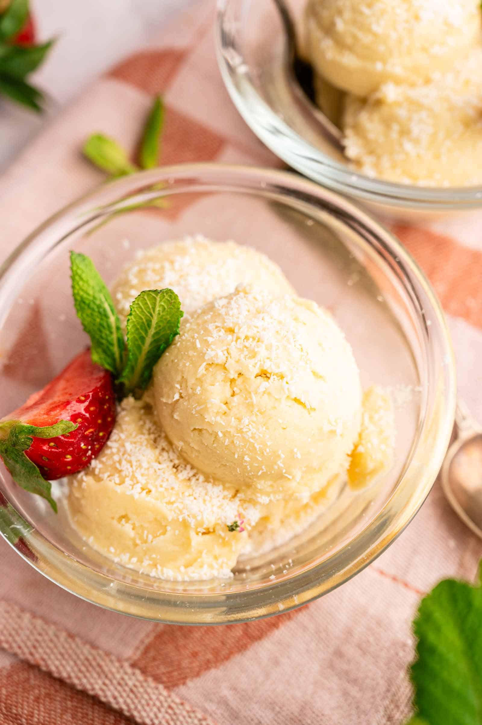 Delicious homemade Dole whip garnished with fresh mint and strawberries. Perfect for summer.