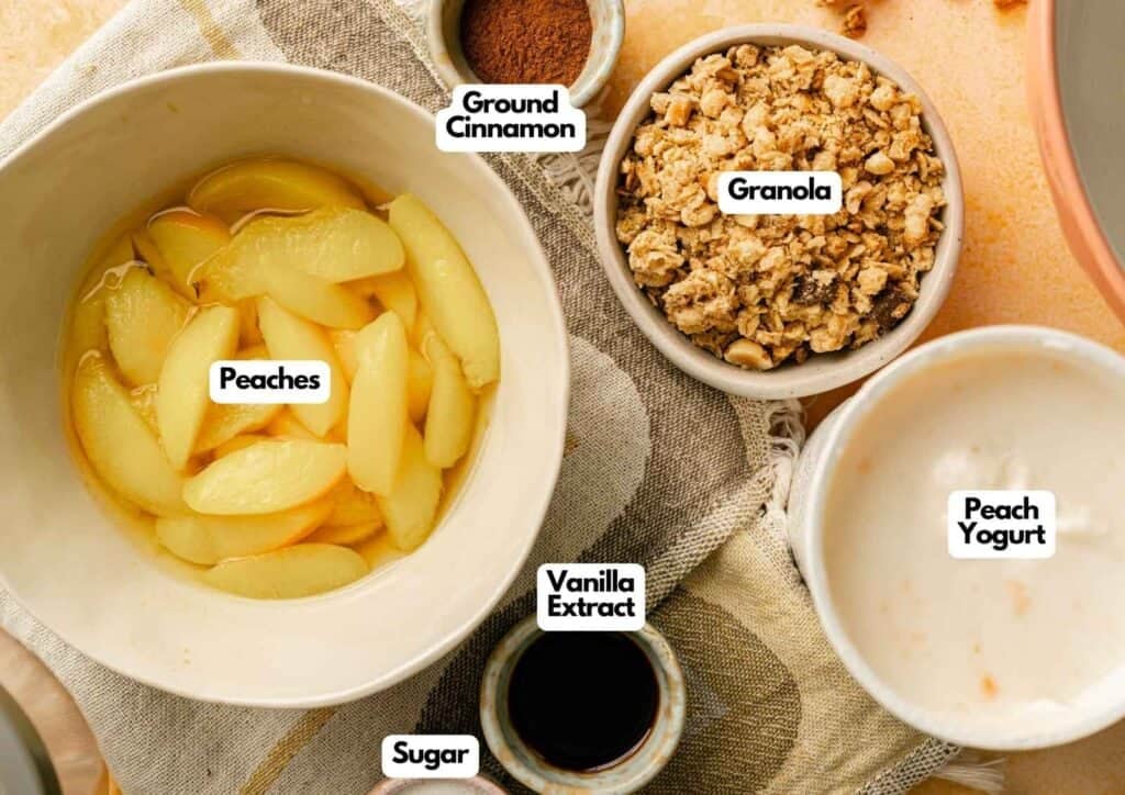 Ingredients for Ninja CREAMi Peach Cobbler Ice Cream including peach yogurt, canned peaches, granola, vanilla extract, sugar, and cinnamon.