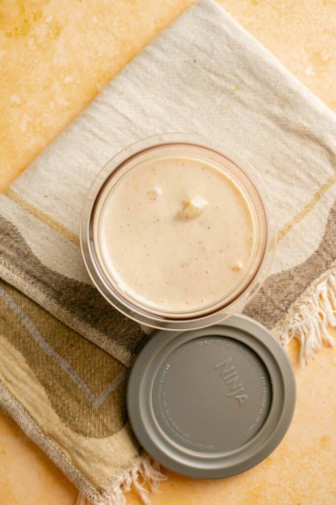 Overhead view of smooth peach cobbler ice cream mixture in a Ninja CREAMi container